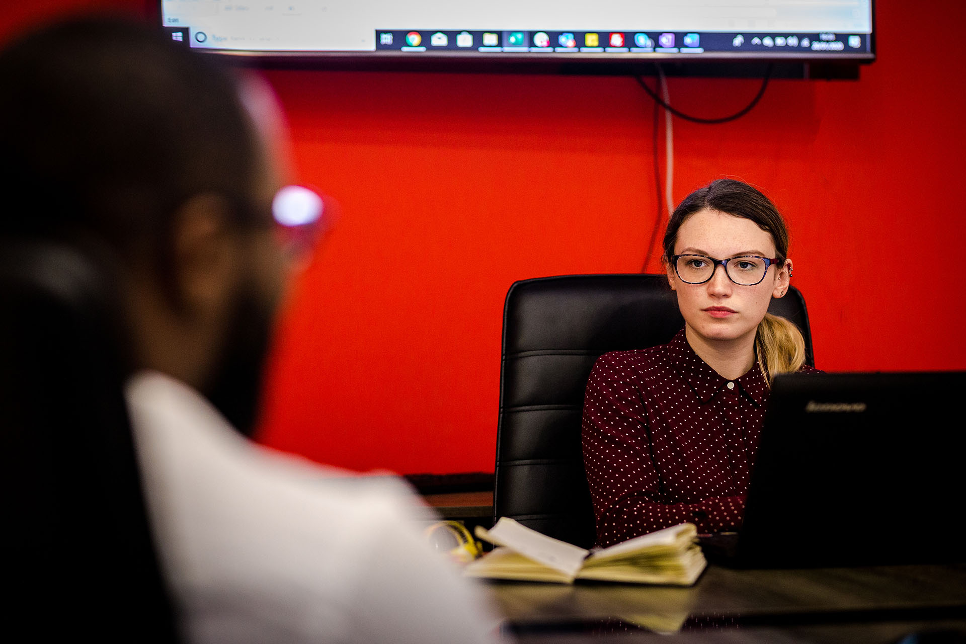 an image of an active win employee sat at her desk sat opposite a man having a conversation